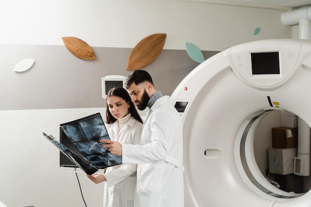 Kollegen Radiologen halten Röntgenstrahlen in ihren Händen nach CT-Computertomographie-Verfahren und besprechen die Diagnose des Patienten
