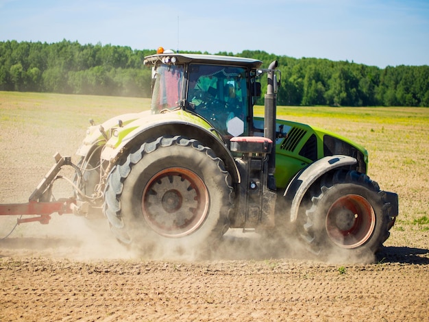 Foto kollektivbauern säen auf dem feld große traktoren, die auf dem feld arbeiten, ernten, geschäfte machen, landwirtschaftliche bodenvorbereitung für das pflanzen