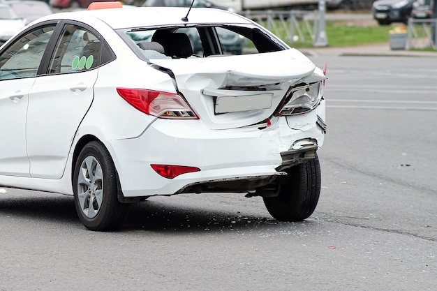 Kollision von Autos. Der weiße Taxiwagen erlitt schwere Schäden am Heck der Karosserie. Stoßstange und Kofferraumdeckel kaputt.