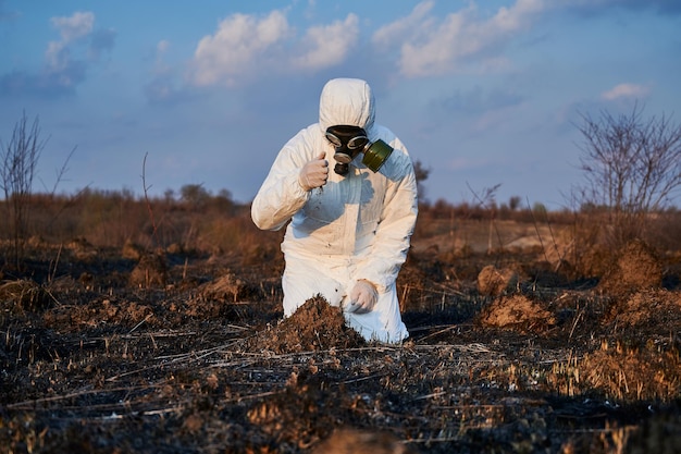 Ökologe untersucht den Boden im Feld nach einem Brand