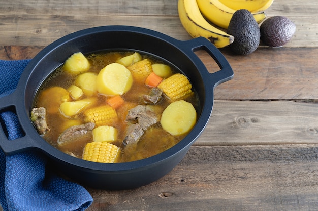 Kolumbianischer Sancocho frisch zubereitet in einem Topf auf einem Holzboden. Platz kopieren.