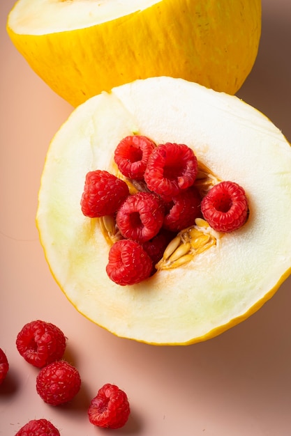 Kombination aus frischen reifen Früchten, Melonen und Himbeeren auf zartem Rosa