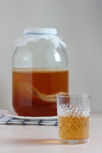 Kombucha en un frasco y en un vaso bebida fermentada agridulce casera con probióticos