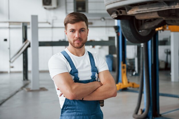 Kommen Sie jeden Tag zu uns, wenn Sie Probleme mit Ihrem Auto haben. Mitarbeiter in der blau gefärbten Uniform arbeitet im Autosalon