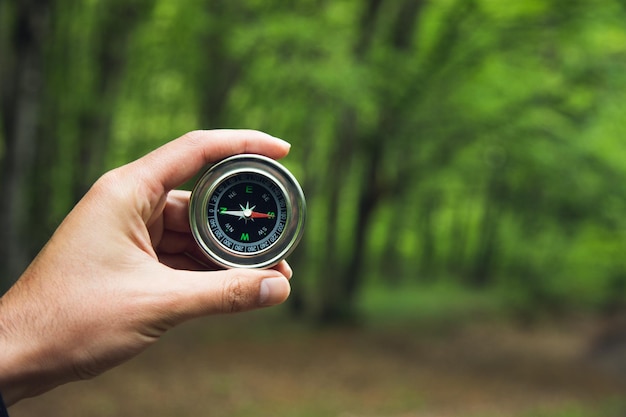 Kompass in der Hand des Mannes im Wald