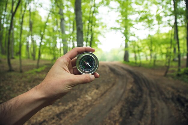 Kompass in der Hand des Mannes im Wald