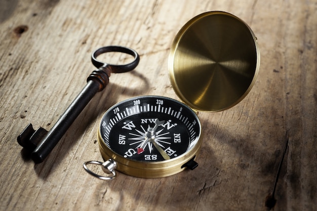 Foto kompass und antiker schlüssel liegen auf einem holz