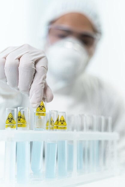 Kompetenter Wissenschaftler mit Schutzausrüstung bei der Arbeit mit Reagenzien im Labor