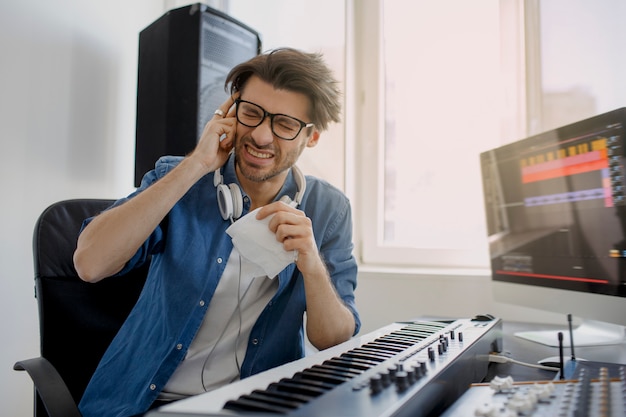 Komponist im Tonstudio. Musikproduktionstechnologie ,. Mann arbeitet am Tonmischer im Aufnahmestudio oder am DJ im Rundfunkstudio.