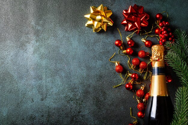 Komposition des neuen Jahres mit goldener Champagnerflasche und Weihnachtsdekor. Neues Jahr flach. Weihnachts-Flatlay. Neues Jahr 2022. Neujahrskonzept