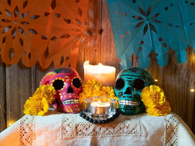 Komposition eines traditionellen Altars für den mexikanischen Tag der Toten mit Totenkopfkerzen und Blumen