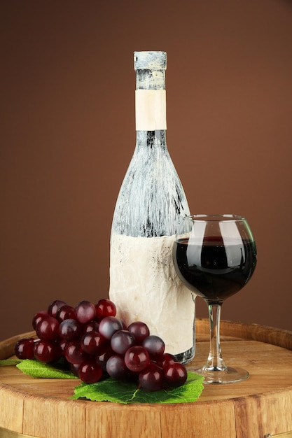 Komposition mit alter Flasche Wein und Weinglas im alten Keller auf dunkelbraunem Hintergrund