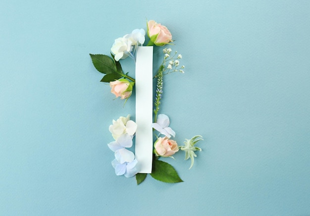 Komposition mit Buchstaben I und schönen Blumen auf farbigem Hintergrund