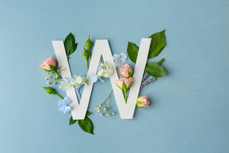 Foto komposition mit buchstaben w und schönen blumen auf farbigem hintergrund
