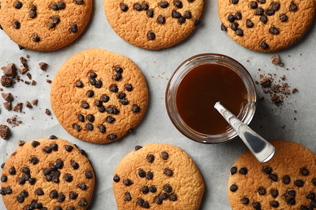 Komposition mit Chip Cookies und Karamell auf grauem Tisch