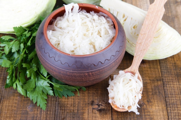 Komposition mit frischem und mariniertem Kohl (Sauerkraut), Gewürzen, auf Holztischplatte