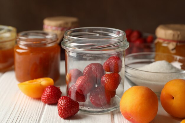 Komposition mit Marmelade auf weißem Holztisch. Marmelade zubereiten