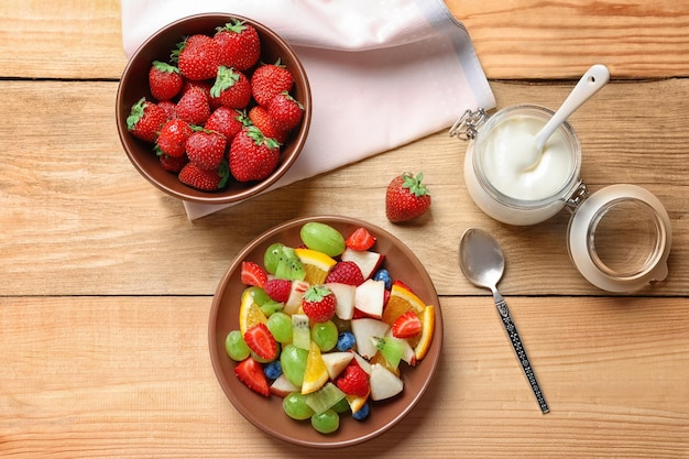 Komposition mit Obstsalat auf Holztisch