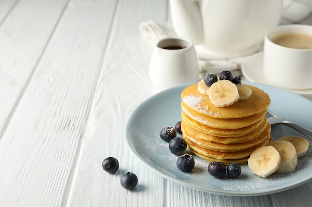 Komposition mit Pfannkuchen, Banane und Blaubeere auf Holztisch. Süßes Frühstück