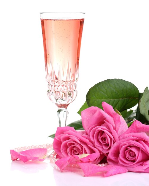 Komposition mit rosa Sekt im Glas und rosa Rosen, isoliert auf weiss