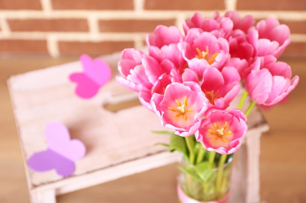 Komposition mit Tulpenstrauß in Vase, auf Leiter, auf Wandhintergrund