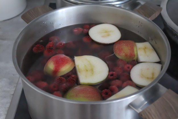 Kompott aus Äpfeln und Beeren in einem Topf auf dem Herd.