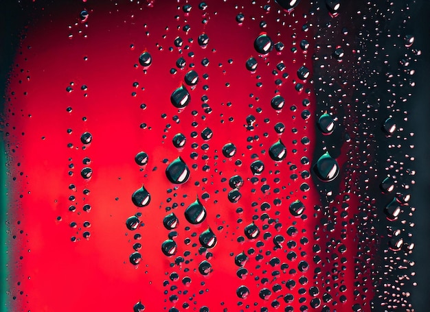 Kondenswassertropfen auf Glas mit rotem und schwarzem Hintergrundrot
