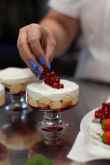 Konditor dekoriert Dessert mit Beeren