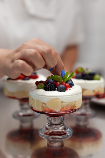 Konditor dekoriert Dessert mit Beeren