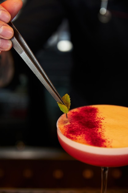 Konditor dekoriert Dessert mit Minzblättern im Restaurant