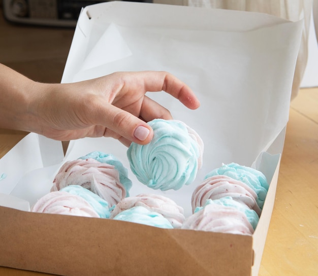 Konditor der jungen Frau stellt Marshmallows in eine Kiste Kleines Hauptgeschäft