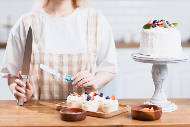 Konditor Konditor junge kaukasische Frau mit Kuchen auf Küchentisch