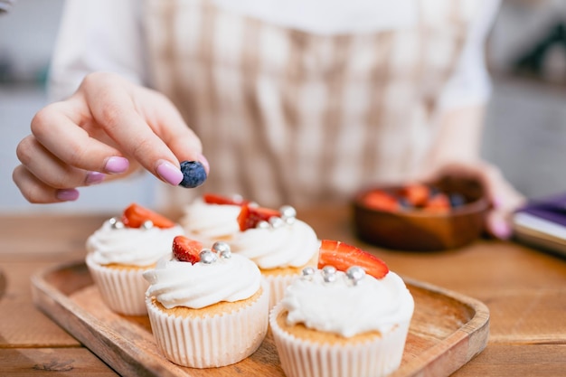 Konditor Konditor junge kaukasische Frau mit Kuchen auf Küchentisch