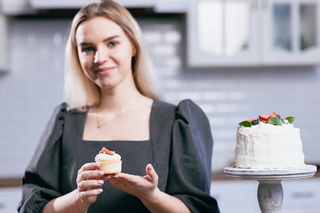 Konditor Konditor junge kaukasische Frau mit Kuchen auf Küchentisch