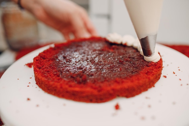 Konditor macht köstlichen roten Samtkuchen Dessert kochen und dekorieren