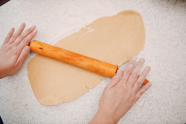 Konditor rollt Teig mit Nudelholz aus und macht köstliche Ingwerkekse. Dessert kochen und dekorieren