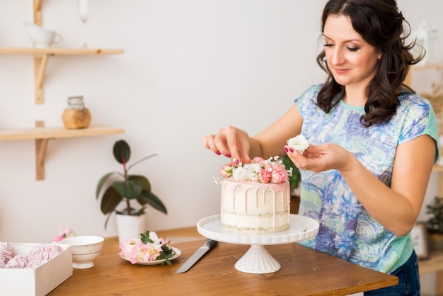 Konditor schmückt den Kuchen mit Blumen