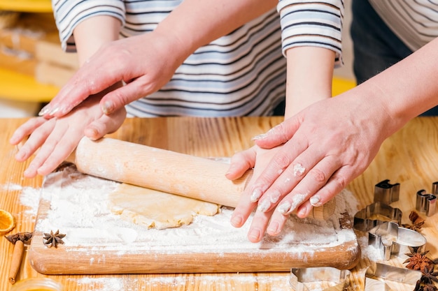 Konditorei-Meisterklasse Schnappschuss einer Frau, die lehrt, wie man Teig rollt, um Lebkuchenkekse herzustellen