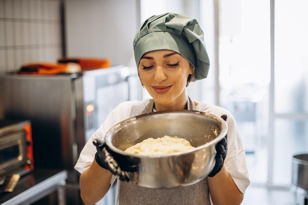 Konditorin in der Küche macht Teig für Croissants