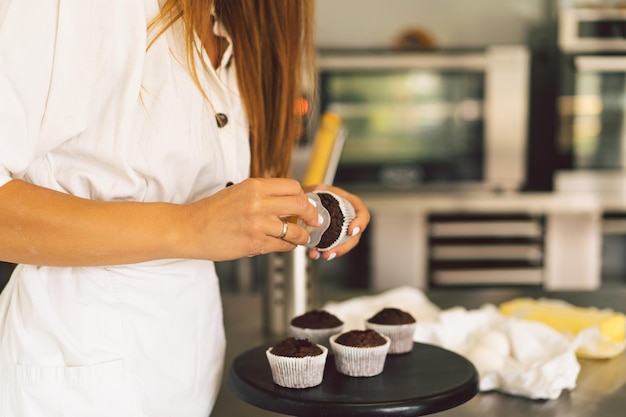 Konditormädchen bereitet Zutaten für ein Cupcake-Konzept zum Kochen von Mehlprodukten oder Desserts vor