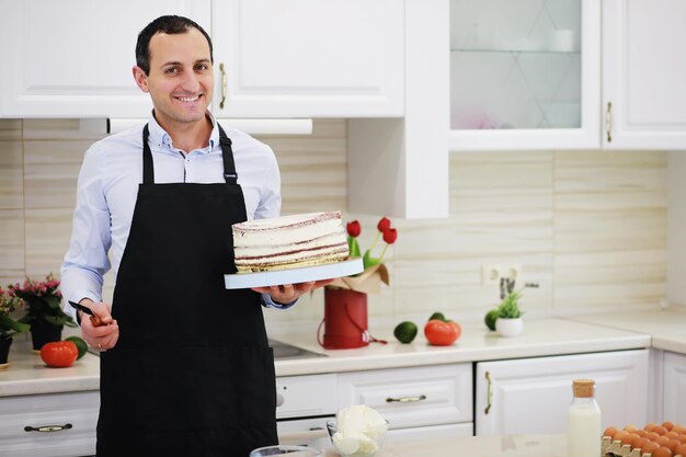 Konditormeister vor einem Schreibtisch. Desserts zu Hause kochen. Der armenische Mann beschäftigt sich mit Süßwaren.