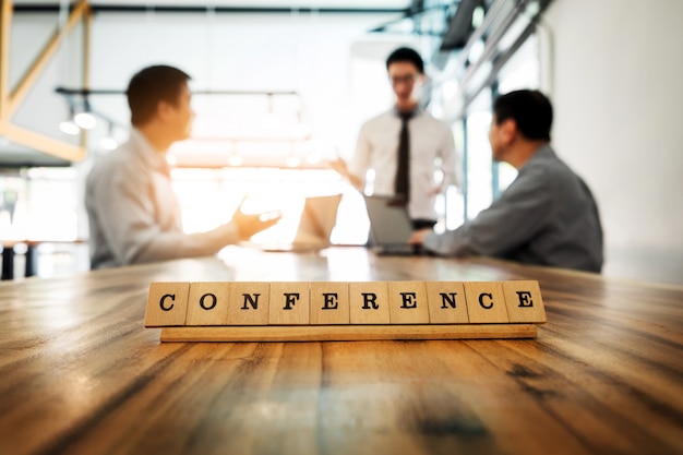 Konferenz Wort auf Holz Tisch mit Business-Team Arbeit Diskussion zusammen Konzept im Hintergrund.