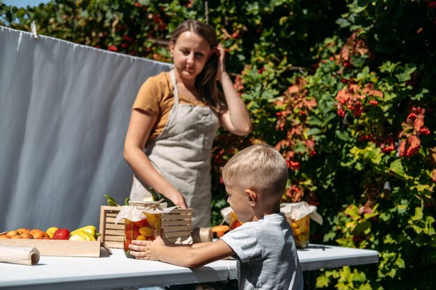 Konserven Gartengemüse Konservierung von Tomaten Paprika Zucchini Gemüse Mama und Sohn in Dosen