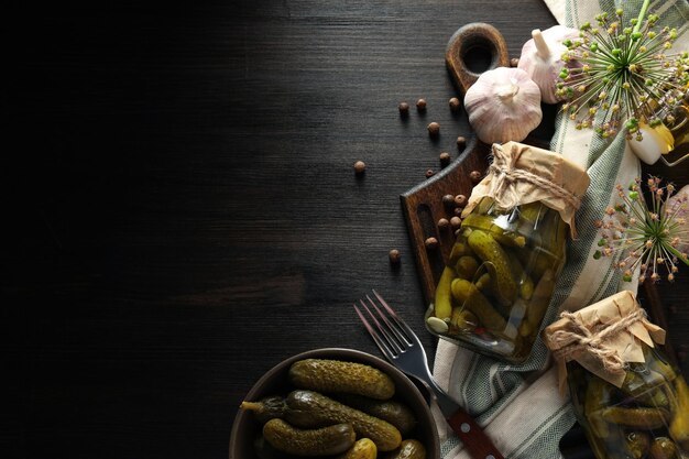 Foto konservierte gurken in einem glas mit zutaten auf einem dunklen tisch
