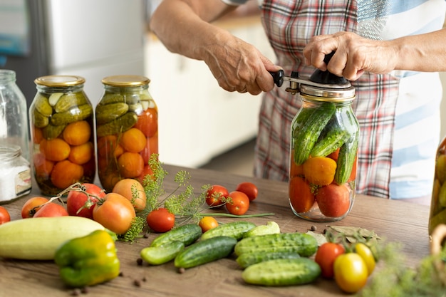 Konservierung von Tomaten und Gurken, die Ernte wird in Gläsern gesalzen