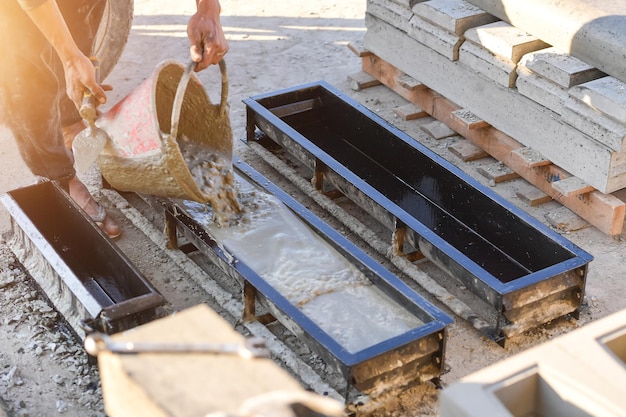 Foto konstruktionsdetails - arbeiter, der zement oder beton mit brickblock verlegt, bauarbeiter