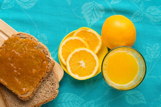 Kontinentales Frühstück mit Orangensaft, Brot und Marmelade