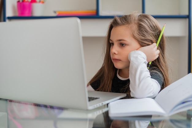 Konzentrieren Sie sich auf das Lernen von Kindern für die Schule auf einem Laptop an einem Online-Kurs für Kindermädchen