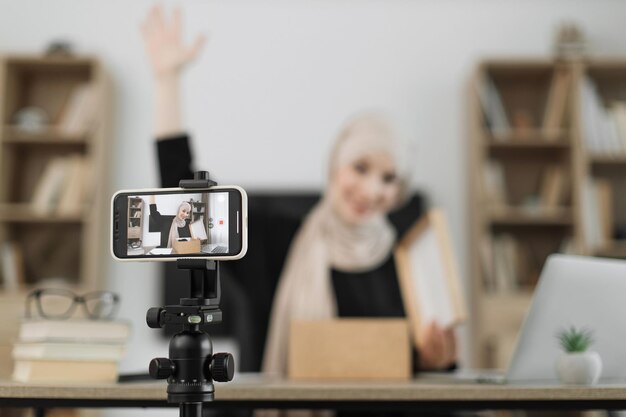 Konzentrieren Sie sich auf den Bildschirm des Smartphones angenehme arabische Frau, die Videos mit einer modernen Telefonkamera filmt