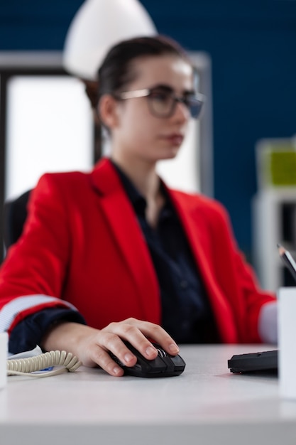 Konzentrieren Sie sich auf die Hand der Geschäftsfrau, die Computermaus hält, die im Unternehmensbürounternehmer arbeitet